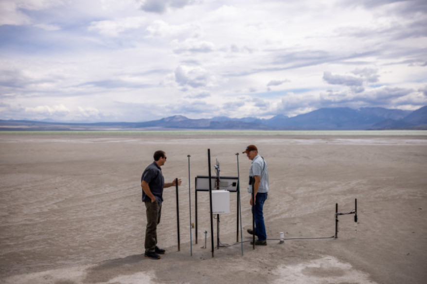 Phill Kiddoo, air pollution control officer for the Great Basin Unified Air Pollution Control District, and Geoffrey McQuilkin, executive director of the Mono Lake Committee, check out an air quality monitor while taking journalists on a tour of the north shore of Mono Lake in Mono County, California, on Tuesday, Aug. 9, 2022.