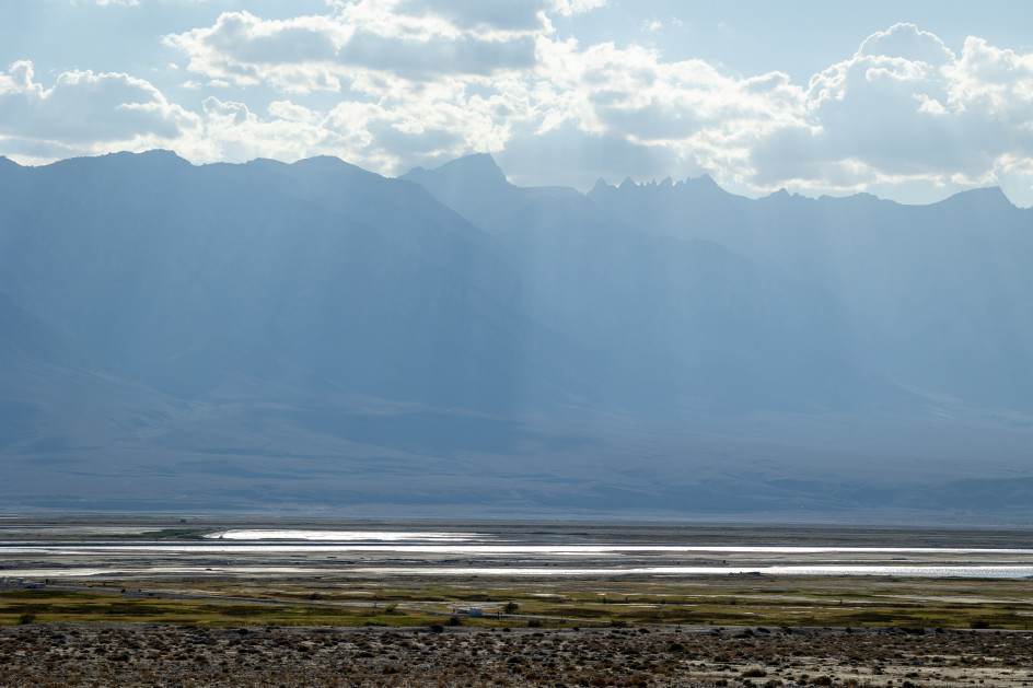 Sun glints off parts of the Owens Lake Dust Mitigation Program, which uses shallow flood, brine pools and other “best available control measures” to reduce blowing dust on the dry lakebed in Inyo County, California, on Wednesday, Aug. 10, 2022.