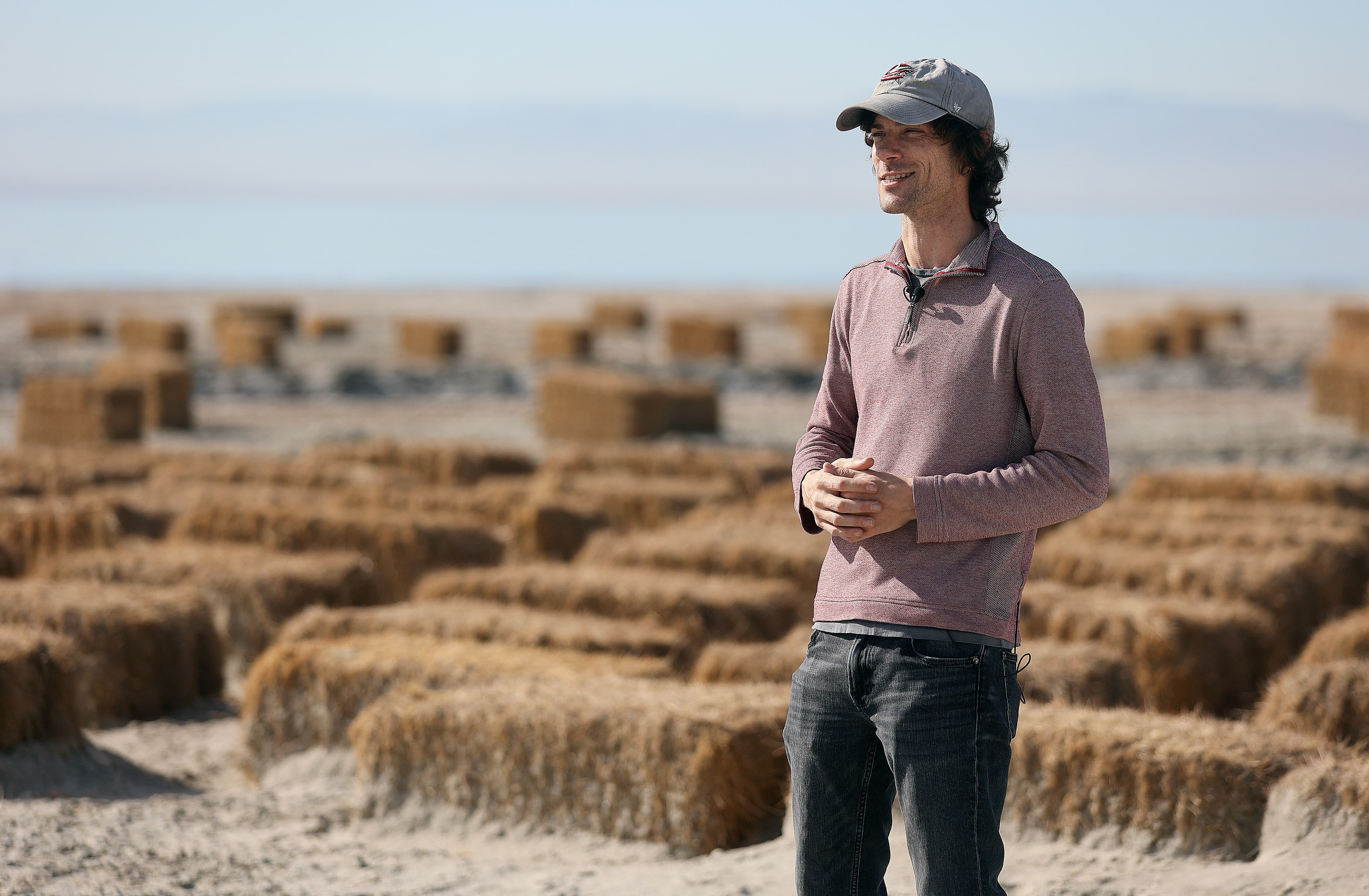 Charlie Diamond, University of California, Riverside, Earth and Planetary Sciences Department academic coordinator, talks about the Salton Sea during an interview in front of hay bales used for dust mitigation by Bombay Beach, Calif., on Tuesday, Dec. 12, 2023.