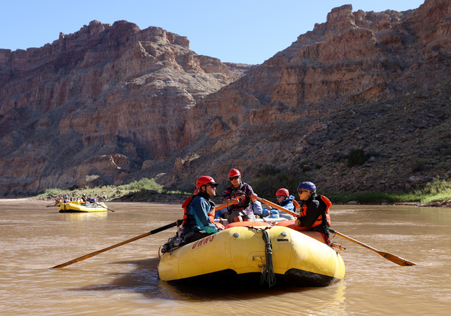 Deseret News reporter Emma Pitts, right, talks with Luke Runyon, The Water Desk co-director, as Jamie Moulton, OARS river guide, guides the boat on a trip with Returning Rapids in Cataract Canyon on Thursday, Sept. 19, 2024. Anne Castle, U.S. commissioner for the Upper Colorado River Commission, sits in the back.