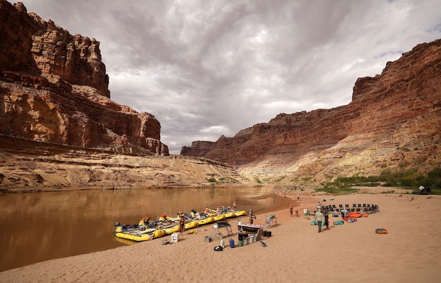 A giant wall of sediment, several stories high and known as the Dominy Formation, lines the far river bank and protrudes into the Colorado River, obscuring the view around the river’s bend, at Rockfall Canyon campsite in Cataract Canyon on Saturday, Sept. 21, 2024. The sediment formation is named after Floyd Dominy, commissioner of the U.S. Bureau of Reclamation in 1963, who was responsible for the dam and Lake Powell. When asked about the future effects of sediment on the Colorado River, Floyd replied, “We will let people worry about it in the future.”