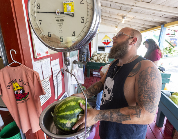 Cody Arthur from Moab weights a watermelon at the Dunham melon stand in Green River on Saturday, Sept. 21, 2024.