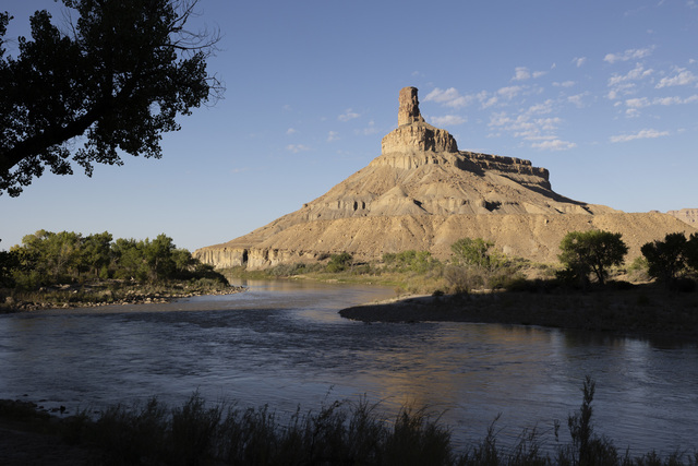 The Green River passes by a bend in the river while an arid mesa rises into the sky during a morning in Green River on Friday, Sept. 20, 2024. The Green River is vital for the melon growers and other farmers in Green River.