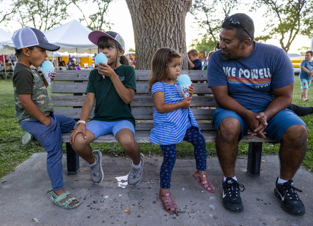 From left to right, Chris Moyes sits with his children Desi, 8, Lylah, 8 and Levi, 4, while they enjoy snow cones during the 118th annual Melon Days Festival in Green River on Friday, Sept. 20, 2024.