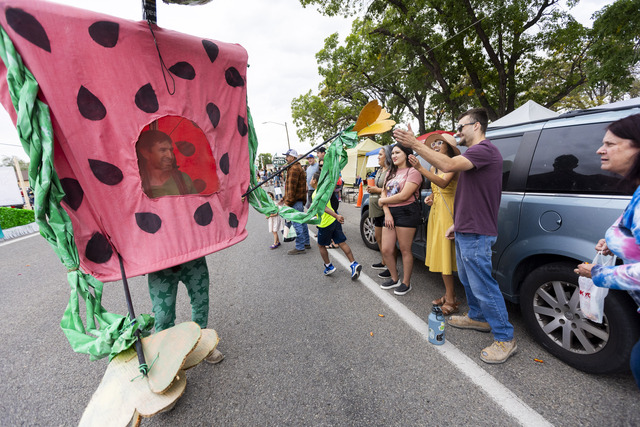 Sam Newman high-fives people along the parade route while dressed as a watermelon with the KZMU radio station float during the 118th annual Melon Days Festival parade in Green River on Saturday, Sept. 21, 2024.