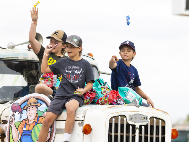 McCoy Nelson, 11, center and Ollie Meadows, 9, right, both from Green River, throw candy from the hood of a truck during the 118th annual Melon Days Festival parade in Green River on Saturday, Sept. 21, 2024. Nelson and Meadows are both part of a past melon growing family, the Nelsons, that grew melons in Green River from 1945-1995.