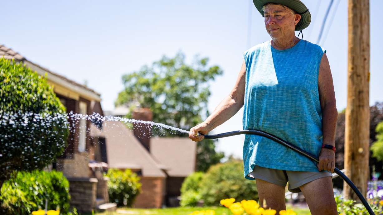Linda Cook waters plants in the Capitol Hill neighborhood in Salt Lake City on Monday, June 9, 2025. Salt Lake County water managers say they've noticed an increase in water consumption again this year after a warmer and drier start to the irrigation season. (Tess Crowley/Deseret News)
