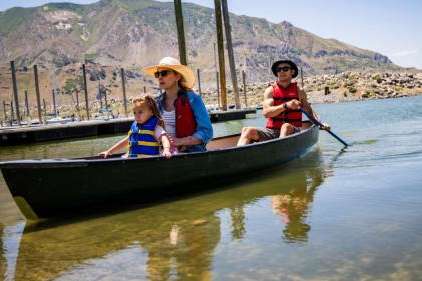 Claire and Tim Gibson and their daughter Elodie Gibson, 2, canoe at Sailfest at the Great Salt Lake on Saturday. Lake levels have already peaked this year and could fall to levels that impact future boating, experts warn. (Tess Crowley/Deseret News)