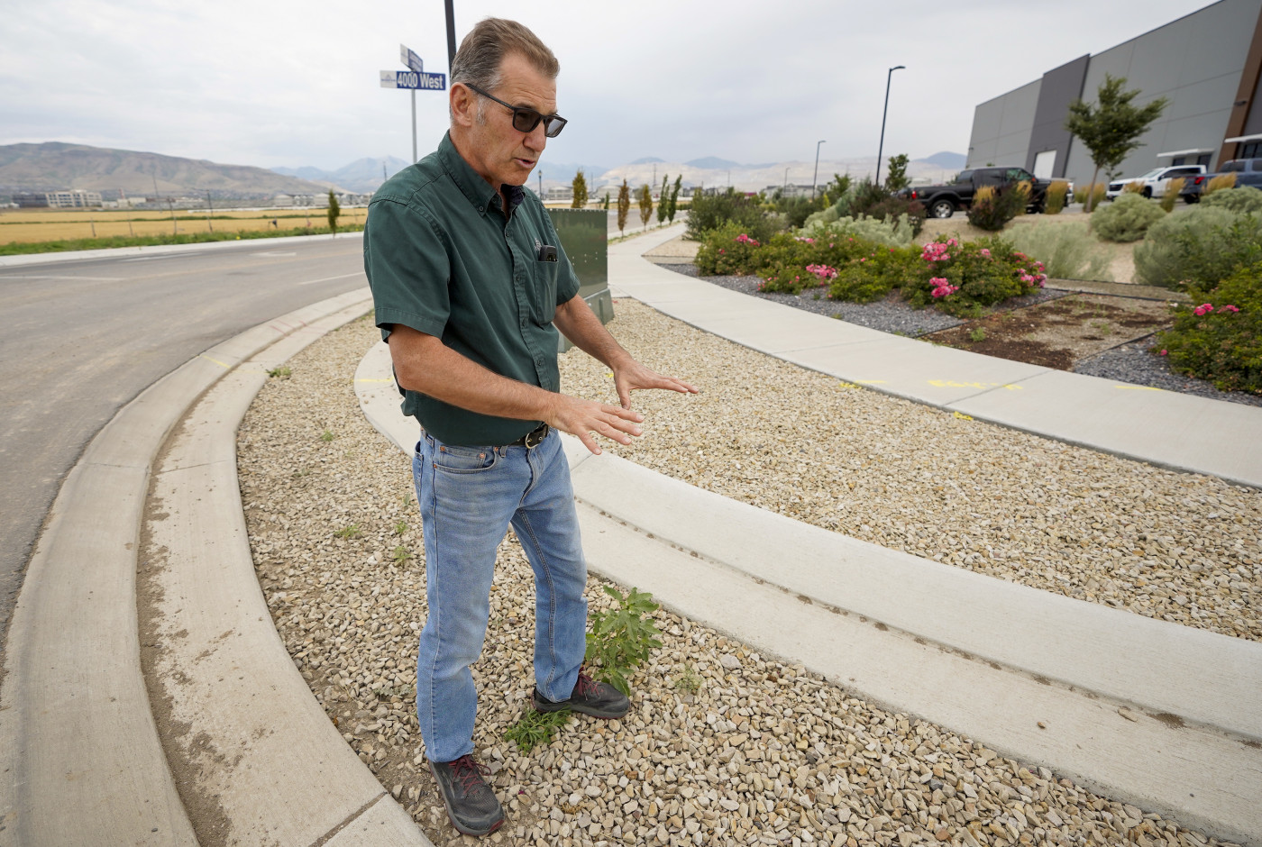 (Chris Samuels | The Salt Lake Tribune) Riverton environmental engineer Tom Beesley shows an example of an urban swale in Riverton, Friday, July 18, 2025. The recessed park strip is intended to capture stormwater and pollution before it enters the city’s sewage.