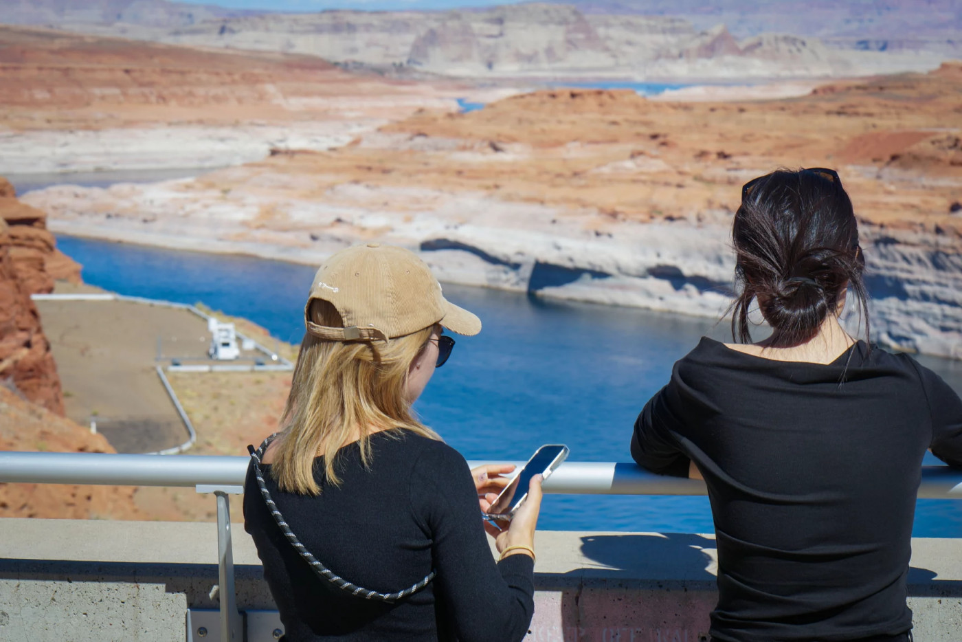 (David Condos, KUER) Visitors look over Lake Powell from a viewpoint at the Glen Canyon Dam, Oct. 5, 2025. Years of drought and overuse across the Colorado River Basin have shrunk water levels at Lake Powell, the nation’s second-largest reservoir.