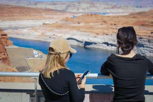 (David Condos, KUER) Visitors look over Lake Powell from a viewpoint at the Glen Canyon Dam, Oct. 5, 2025. Years of drought and overuse across the Colorado River Basin have shrunk water levels at Lake Powell, the nation’s second-largest reservoir.