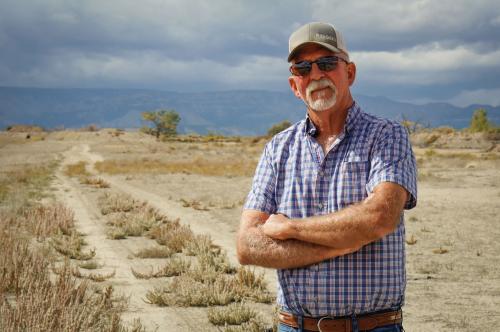 (David Condos | KUER) Carbon County farmer Kevin Cotner stands next to a bare field south of Price, Sept. 30, 2025. He’s one of around a dozen Utah farmers who are leaving some of their land unplanted and unirrigated this year as part of a state effort to leave more water for the Colorado River.
