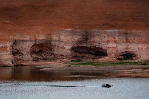 (Francisco Kjolseth | The Salt Lake Tribune) A boat makes its way to Bullfrog Marina on Lake Powell as high water marks indicate how much the reservoir has receded on Friday, April 24, 2026.