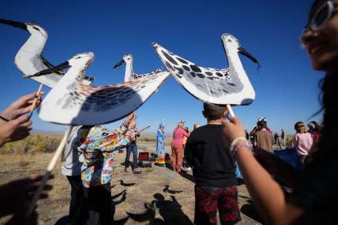 (Francisco Kjolseth | The Salt Lake Tribune) Bird costumes are distributed to 6th graders as they participate in a call to action to save the bird during a rally at the Great Salt Lake on Wednesday, Oct. 1, 2025.