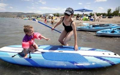 Christine Ray pushes daughter Bonnie Ray on a paddle board at Bear Lake’s Rendezvous Beach in Rich County on Wednesday, June 29, 2022. A new study reveals visitors to Bear Lake last summer pumped $48 million into the northern Utah region during more than a million days and nights of visitation.Kristin Murphy, Deseret News