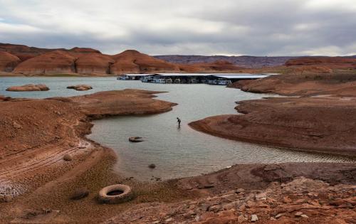(Francisco Kjolseth | The Salt Lake Tribune) A fisherman tries his luck in the receding waters near Bullfrog Marina at Lake Powell on Friday, Saturday, April 24, 2026. Glen Canyon National Recreation Area officials plan to move the marina to the deeper waters in the main channel of the reservoir across from Halls Crossing.