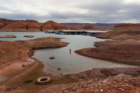 (Francisco Kjolseth | The Salt Lake Tribune) A fisherman tries his luck in the receding waters near Bullfrog Marina at Lake Powell on Friday, Saturday, April 24, 2026. Glen Canyon National Recreation Area officials plan to move the marina to the deeper waters in the main channel of the reservoir across from Halls Crossing.