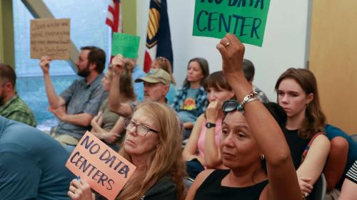 Lorena Bush holds a NO DATA CENTER sign during a public hearing in Salt Lake City on Monday. Opponents are concerned a permit would authorize the discharge of up to 260,000 gallons per day of concentrated industrial brine. (Kristin Murphy, Deseret News)