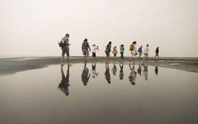 Visitors to Silver Sand Beach at the Great Salt Lake Marina are reflected on still water as they walk around during a rainstorm on Aug. 18, 2021.  Shafkat Anowar, Deseret News