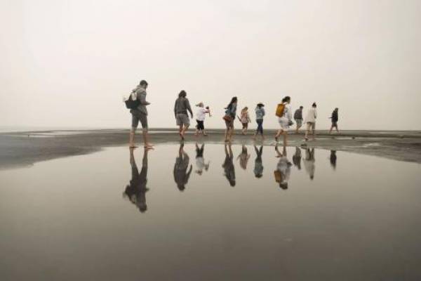 Visitors to Silver Sand Beach at the Great Salt Lake Marina are reflected on still water as they walk around during a rainstorm on Aug. 18, 2021.  Shafkat Anowar, Deseret News