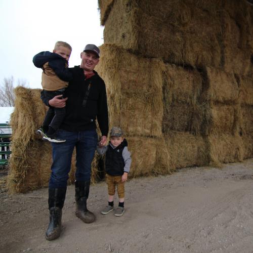 Kelby Johnson with his sons Luke (in his arms) and Wyatt. Johnson runs a 100-acre farm in Benson, Utah, and hopes his children will become fifth-generation family farmers. But the Johnsons must withstand pressure to sell to developers and cut costs and water for the Great Salt Lake. (Jeffrey Dahdah, KSL-TV).