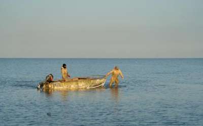 Fishermen drag a boat through the shallow waters of the Aral Sea in western Kazakhstan to a point where the water becomes deep enough to start the engines. Abduaziz Madyarov / Special For The Great Salt Lake Collaborative