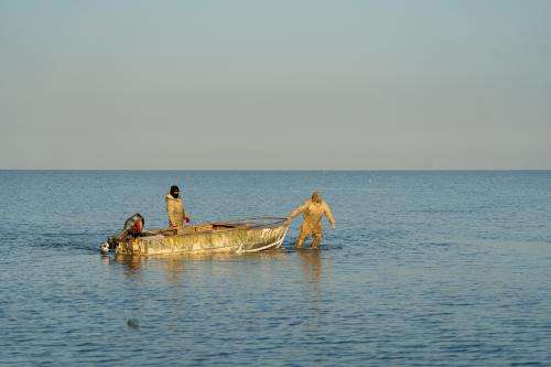 Fishermen drag a boat through the shallow waters of the Aral Sea in western Kazakhstan to a point where the water becomes deep enough to start the engines. Abduaziz Madyarov / Special For The Great Salt Lake Collaborative