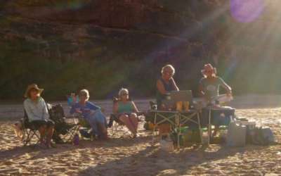 Group of women rafters cooking and relaxing on the bank of the river. (Photo courtesy Zan Merrill).