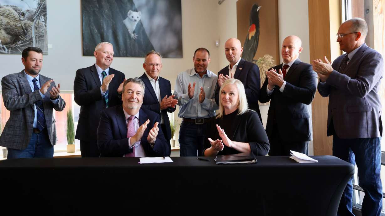 Compass Minerals CEO Edward Dowling, front left, and Utah Forestry, Fire and State Lands Director Jamie Barnes, front right, as well as Utah leaders applaud after a water conservation deal is finalized on Tuesday. The deal includes over 200,000 acre-feet directed to the Great Salt Lake every year, according to the state. (Kristin Murphy, Deseret News)