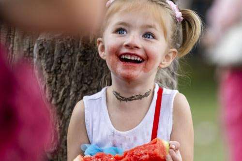 Aurora Tucker, 5, from Grand Junction, Colorado, laughs with a watermelon stained face while eating watermelon during the 118th annual Melon Days Festival in Green River on Saturday, Sept. 21, 2024. Tucker has been attending the Melon Days festival to enjoy watermelon for her entire life so far. Brice Tucker, Deseret News