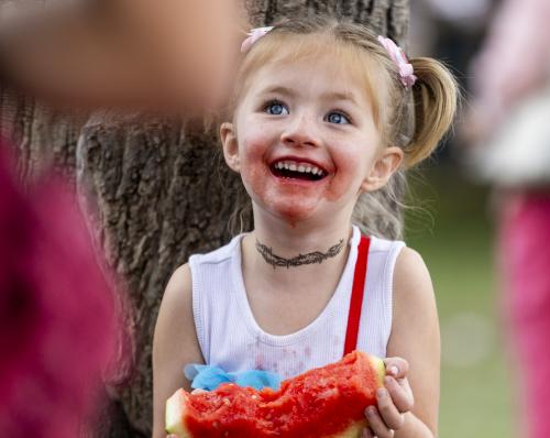 Aurora Tucker, 5, from Grand Junction, Colorado, laughs with a watermelon stained face while eating watermelon during the 118th annual Melon Days Festival in Green River on Saturday, Sept. 21, 2024. Tucker has been attending the Melon Days festival to enjoy watermelon for her entire life so far. Brice Tucker, Deseret News