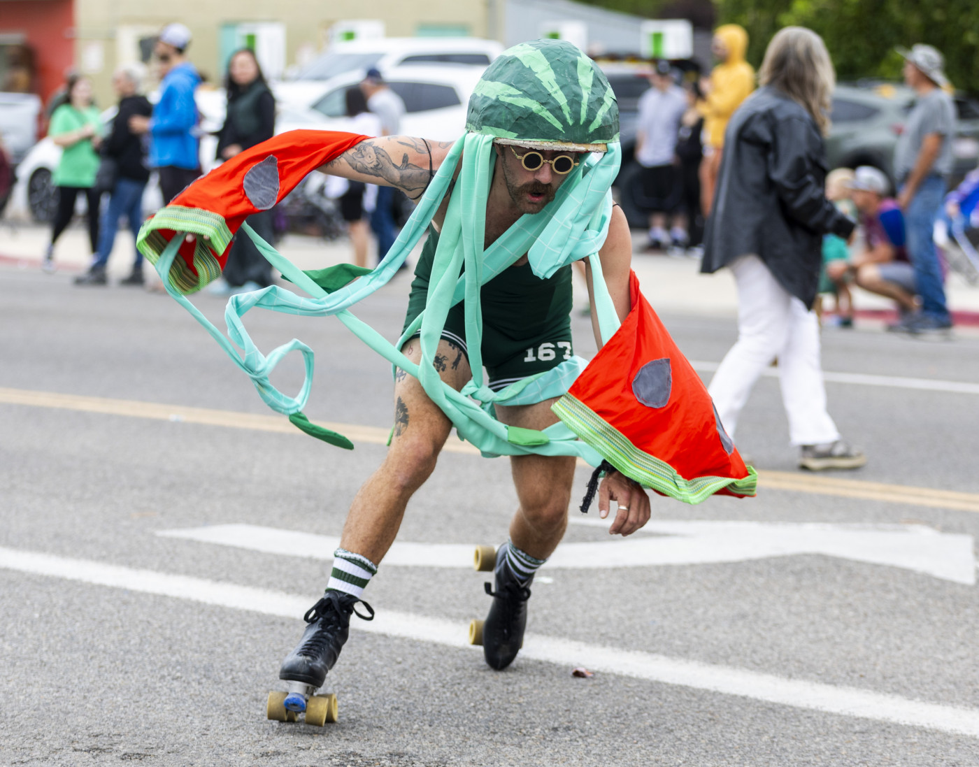 Sam Van Wetter roller skates while dressed as a watermelon with the KZMU radio station float during the 118th annual Melon Days Festival parade in Green River on Saturday, Sept. 21, 2024. | Brice Tucker, Deseret News