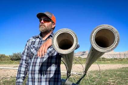 Farmer and rancher Coby Hunt stands next to idle irrigation equipment in one of his fields near the town of Green River, Aug. 19, 2024. Utah is launching a new program that will pay producers to leave their fields empty, as Hunt has done, and leave their irrigation water in the Colorado River system. (David Condos/KUER)