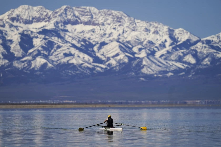 A man rows on the Great Salt Lake on April 15, 2023, in Magna, Utah. Workers, hobbyists and residents who rely on the Great Salt Lake are rejoicing this year after winter's snow melted and led to a 6-foot rise at the lake. (Rick Bowmer/AP)